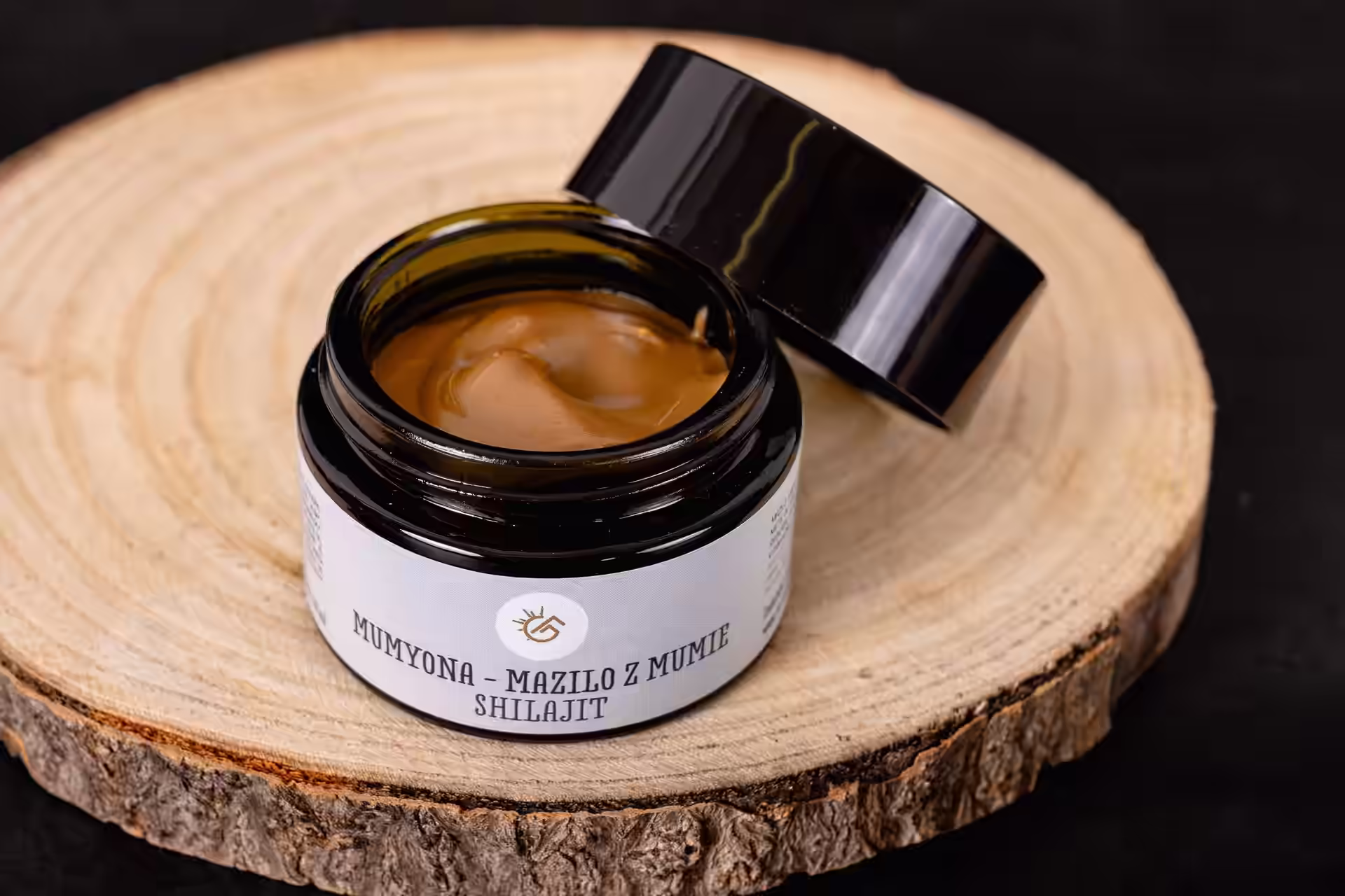 Black jar of Mumyiona-Mazilo z Mumie Shilajit cream on a white surface.